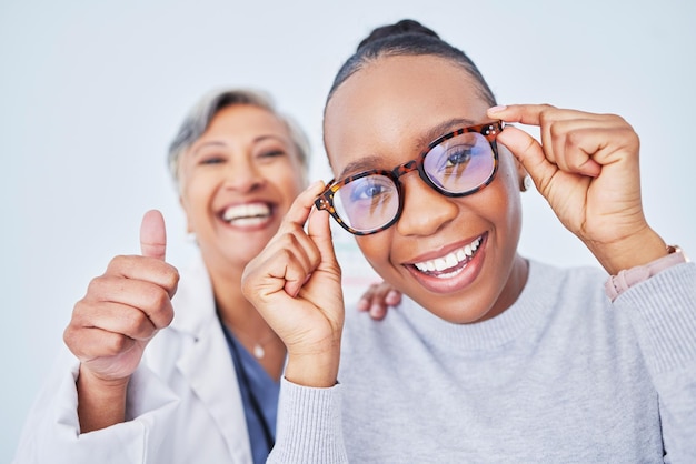 Eye care glasses and patient with doctor women at clinic optometry and frame choice with help and thumbs up Wellness health and prescription lens support from optometrist trust and eyewear