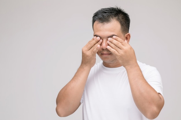 Eye irritation concept : Portrait of Asian man in posture of eye tired,  irritation or problem about his eye. 