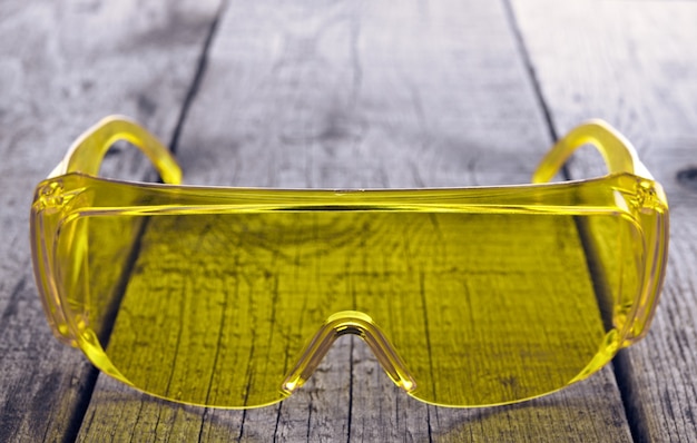 Eye protection glasses for repair and construction work, on a wooden surface