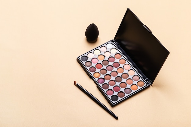 Eye shadow palette, makeup brush and sponge. Minimal beauty cosmetics layout, isometric view.