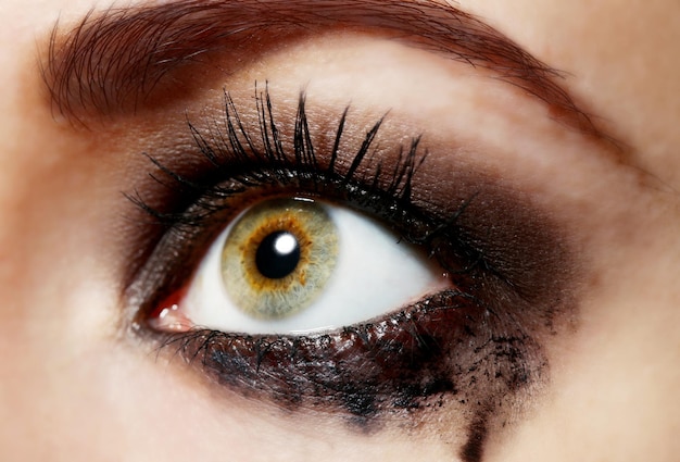 Eye of young woman with tear drop close up