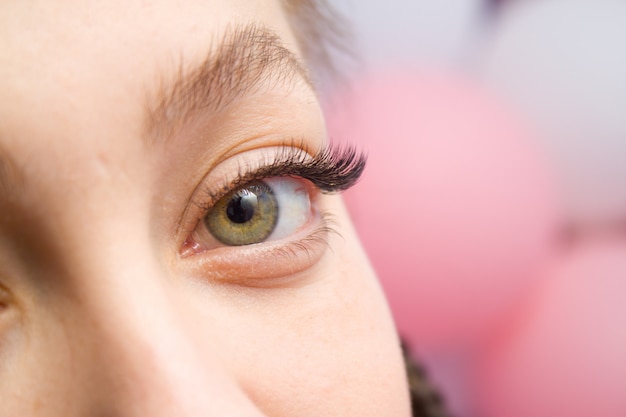 Eyelash Extension Procedure. Woman Eye with Long false Eyelashes. 