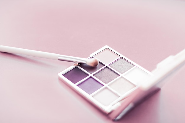 Eyeshadow palette and makeup brush on blush pink background eye shadows cosmetics product as luxury beauty brand promotion and holiday fashion blog design