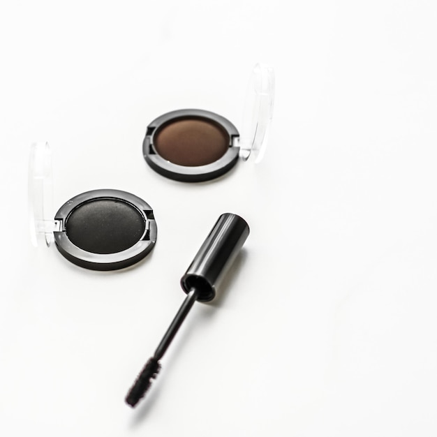 Eyeshadows black liner and mascara on marble background eye shadows cosmetics as glamour makeup products for luxury beauty brand holiday flatlay design