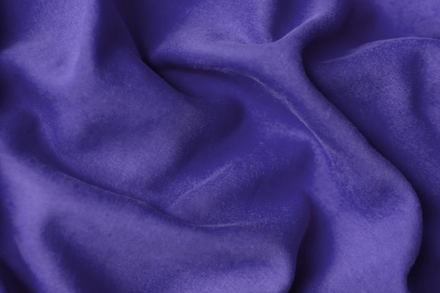 Fabric with waves colored in violet color of the year 2022. Trendy color very peri. Fabric backdrop, cloth texture, view from above.