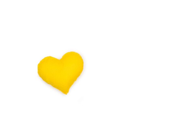 A fabric yellow heart on a white background with copy space