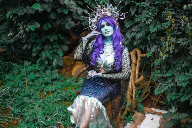 fabulous dark mermaid with blue skin in the forest closeup