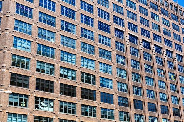 Facade of brick building with wooden windows.