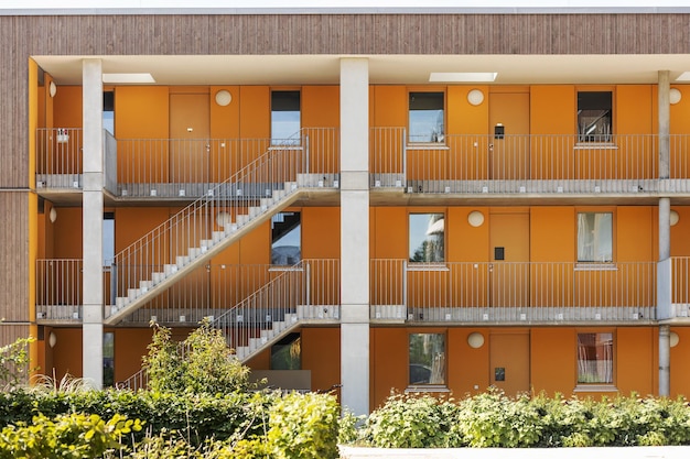 Facade Building Condominium with Outdoor Stairs. Modern Facade Residential Building with Landscape.