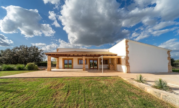 Facade of a country house in Majorca with clouds on a blue sky over it