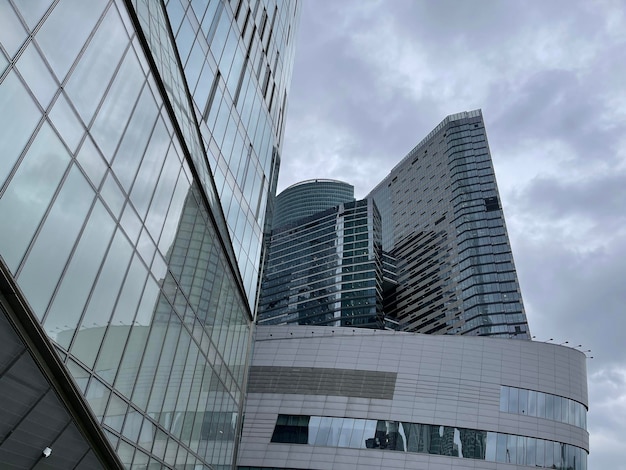 Facade of modern skyscraper with glass walls From below of contemporary tall skyscraper with glass walls against cloudy sky in downtown