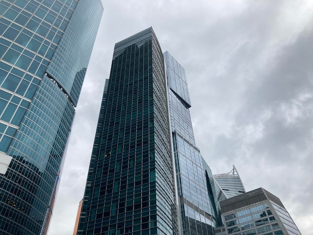 Facade of modern skyscraper with glass walls From below of contemporary tall skyscraper with glass walls against cloudy sky in downtown