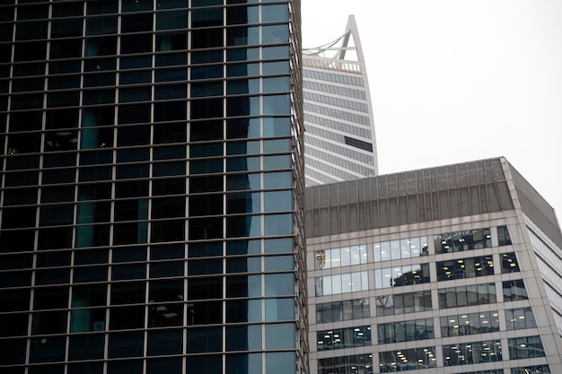 Facade of modern skyscraper with glass walls From below of contemporary tall skyscraper with glass walls against cloudy sky in downtown