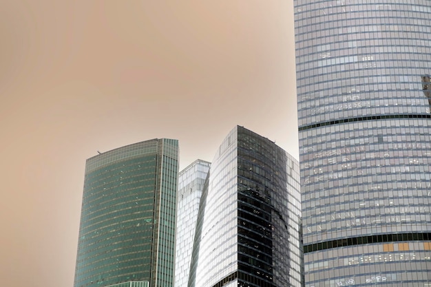 Facade of modern skyscraper with glass walls From below of contemporary tall skyscraper with glass walls against cloudy sky in downtown