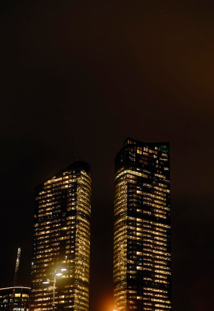 Facade of modern skyscraper with glass walls From below of contemporary tall skyscraper with glass walls at night in downtown