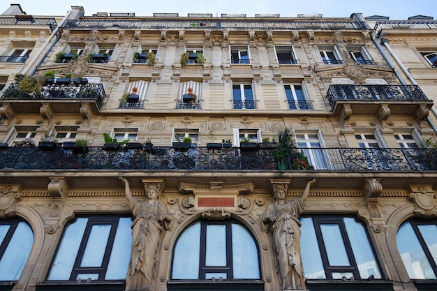 The facade of traditional French house with typical balconies and windows Paris France