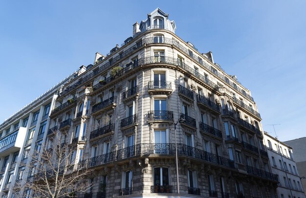 The facade of traditional French house with typical balconies and windows Paris