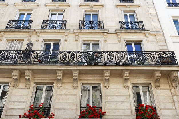 The facade of traditional French house with typical balconies and windows Paris