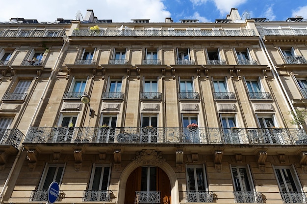 The facade of traditional French house with typical balconies and windows Paris