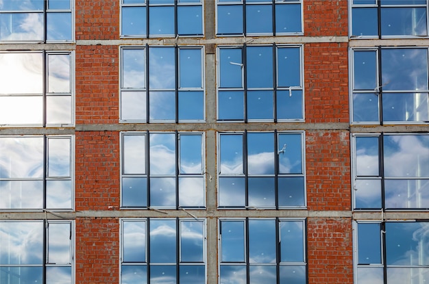 Facades of a multistory building under construction. Construction site, tools, wheel barrow, sand a