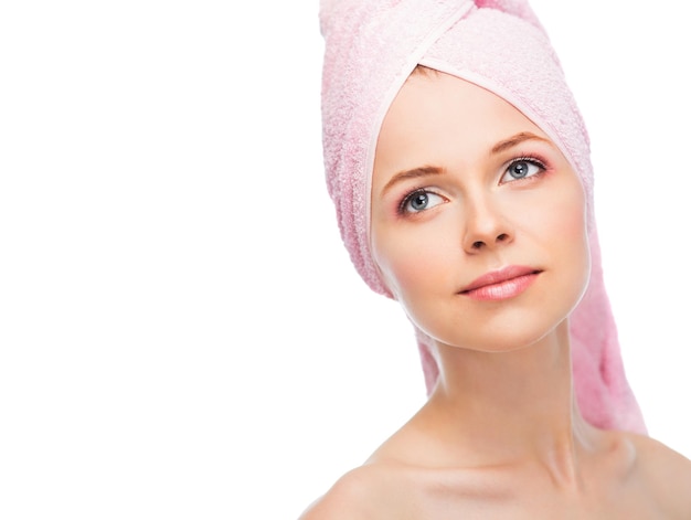 Face of a beautiful young woman with a towel on a white background