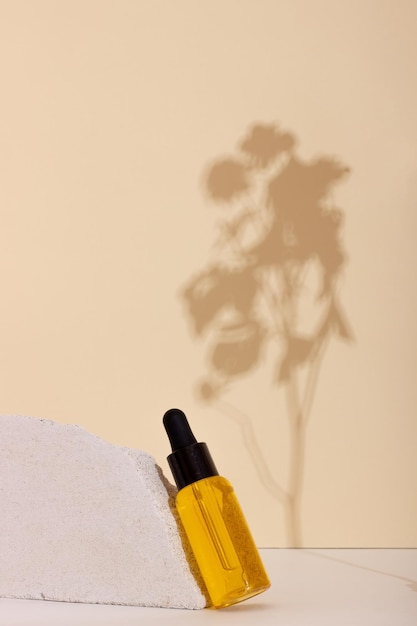 Face and body skin care products in a glass bottle with a pipette against a background of concrete and paper figures Cosmetics for women with natural ingredients Copy space layout