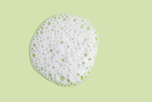 Face cleansing mousse texture on green background