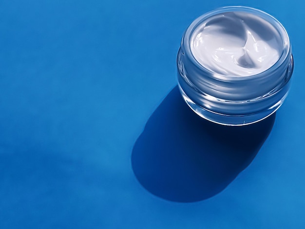 Face cream moisturiser jar as product sample on blue background beauty and skincare cosmetic science