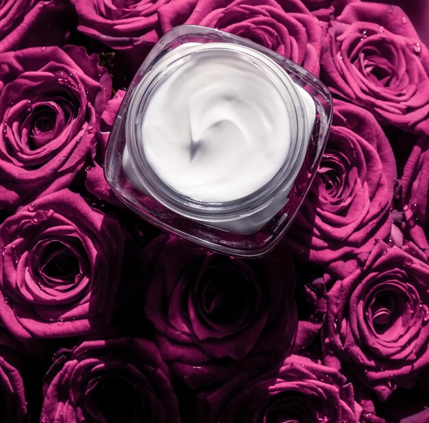 Face cream skin moisturizer on pink roses flowers luxury skincare cosmetic product on floral background as beauty brand holiday flatlay design