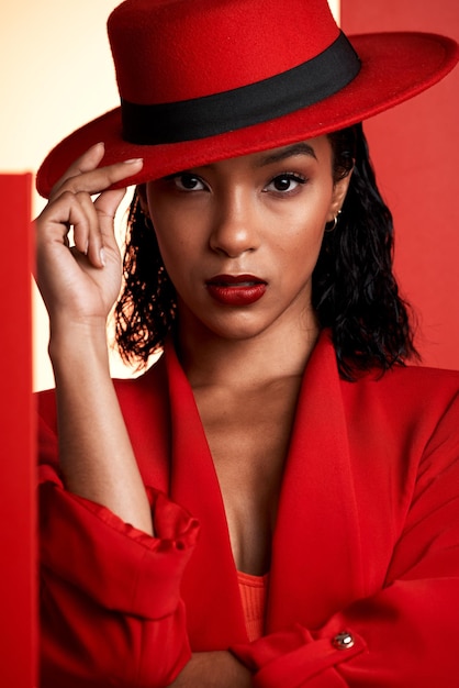 Face fashion and black woman in red hat suit and stylish clothing Portrait beauty and aesthetic of female model from South Africa posing with makeup cosmetics or edgy classy and designer outfit