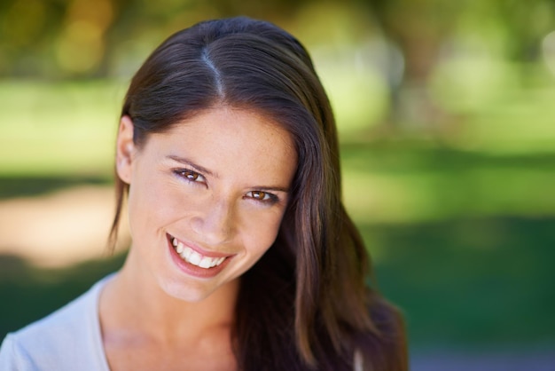 Face happy and portrait of a woman in a park in summer for beauty smile and confident in nature with happiness Head garden and female person or model outdoor with freedom relax and in a forest