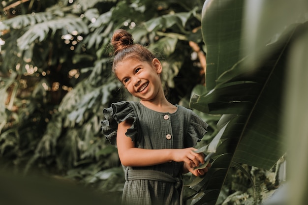 face of a little girl surrounded by tropical leaves Closeup portrait of a beautiful swarthy baby