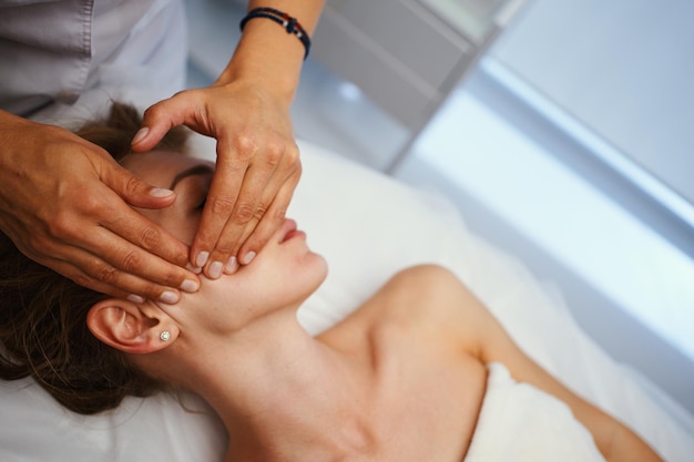 Face massage Young pretty woman having face massage in the salon