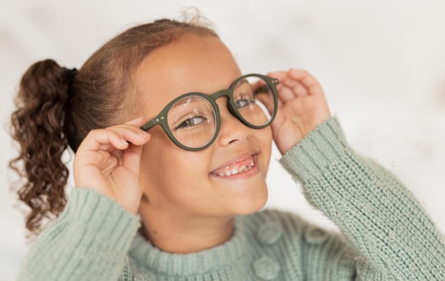 Face portrait child and girl with glasses for optical health at optometrist office Eyes wellness eye care and happy kid with specs spectacles or prescription lenses to help with ocular vision