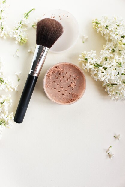 Face powder and brush on white background Copy space