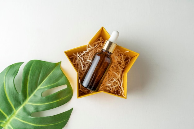 A face serum or essential oil lying in a present box for holidays