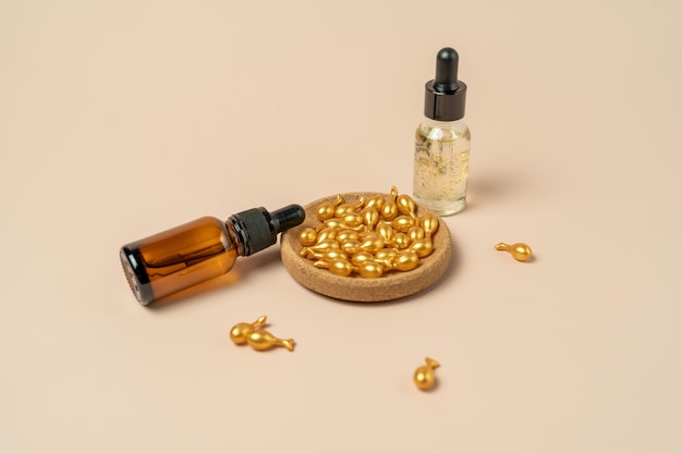 A face serum or oil in golden capsules lying on a beige background