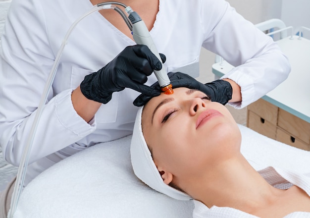 Face Skin Care. Closeup Of Woman Face Cleansing At Cosmetology clinic, vacuum cleaning