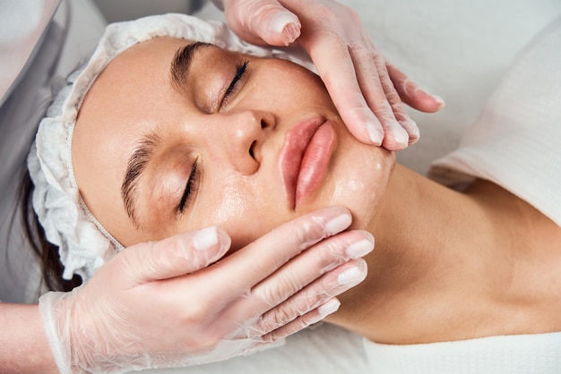 Face skin care closeup of woman getting facial hydro microdermabrasion peeling treatment at cosmetic