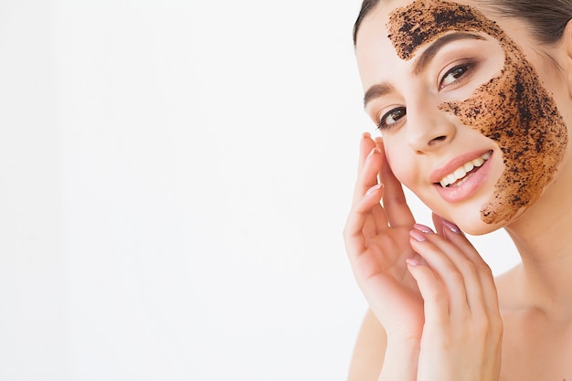 Face Skincare. Young Charming Girl Makes a Black Charcoal Mask on Her Face