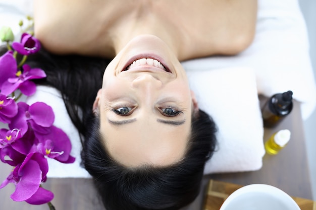 Face of smiling woman in spa. Facial skin care and rejuvenation concept