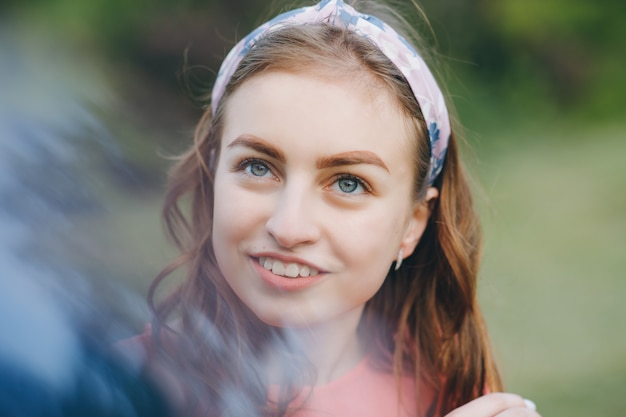 Face young beautiful girl closeups short hair summer park smiling