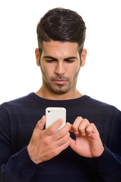 Face of young handsome Persian man using mobile phone