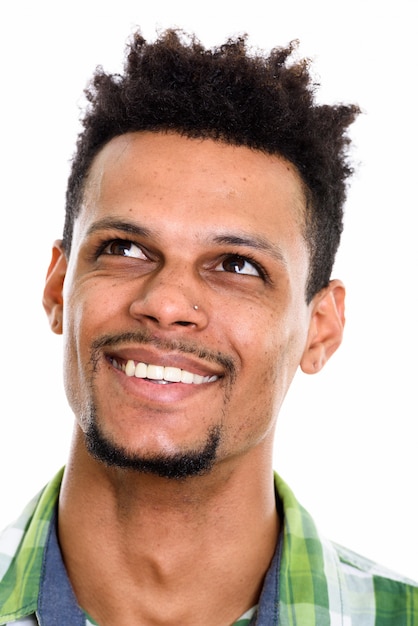 Face of young happy African man smiling while thinking isolated on white