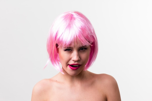 Face of a young woman with bright makeup on a pink background with gathered hair in a smooth ponytail