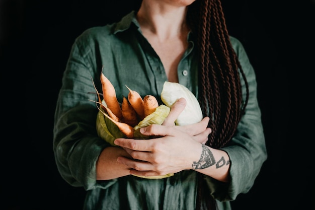 Photo faceless portrait of vegan woman holding vegetables veganism vegetarianism plant-based diet