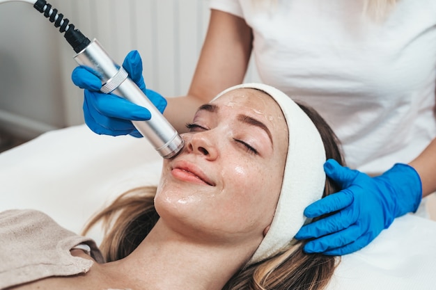 Facial beauty treatment of beautiful young woman with oxygen at cosmetic beauty salon.