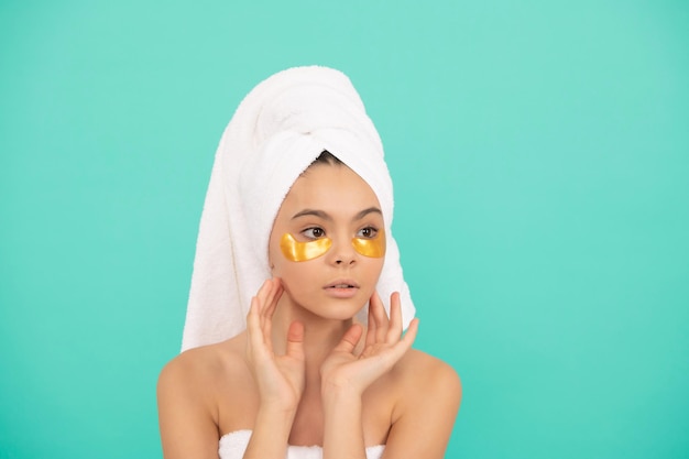 Facial collagen cosmetic. moisturizing skin. cosmetology. child in terry towel use patch. beauty day in spa. applying face undereye mask. teen girl do daily treatment. skincare.