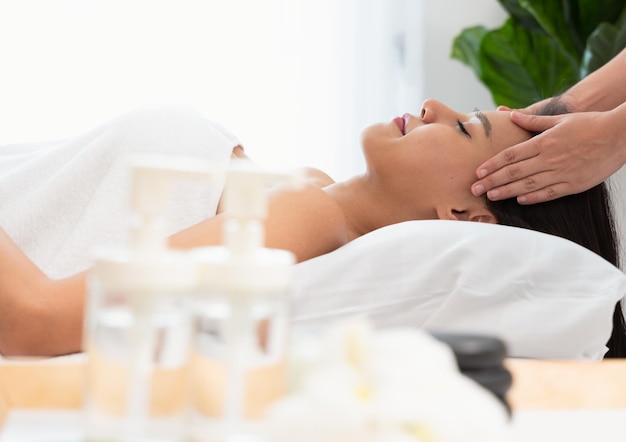 Facial massage treatment Relaxed and calm young woman face getting face lifting massage in spa salon