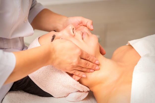 Facial massage Young caucasian woman getting a massage on her neck in a beauty clinic